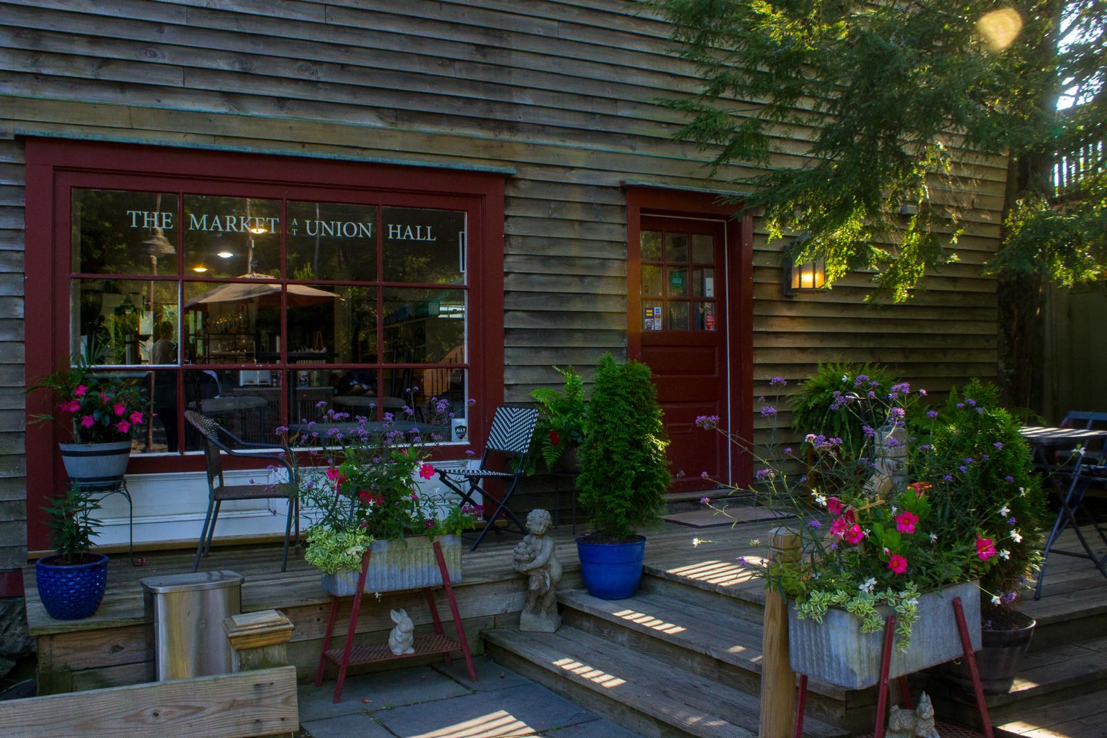 Exterior of The Market at Union Hall in North Salem with red trim, flowers, and outdoor seating